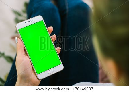 Beautiful girl holding a smartphone in the hands of a green screen green screen, hand of man holding mobile smart phone with chroma key green screen on white background, new technology concept