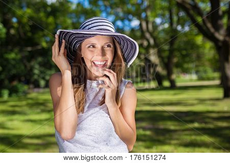 Pretty Carefree Woman In Hat Outside Looking Away