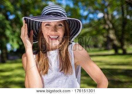 Beautiful Happy Woman Holding Hat Standing Outside