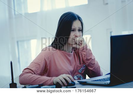 sad and scared female teenager with computer laptop suffering cyberbullying and harassment being online feeling desperate and humiliated in cyber bullying concept