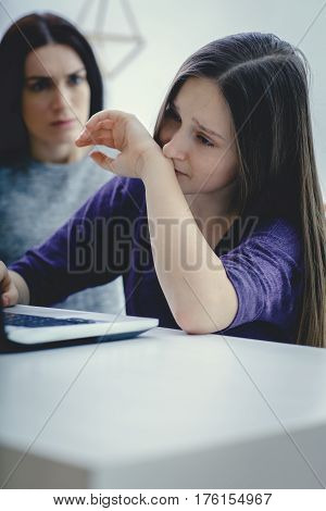 Scared mother arguing daughter over online activity. Cyber bullying or blue whale game concept