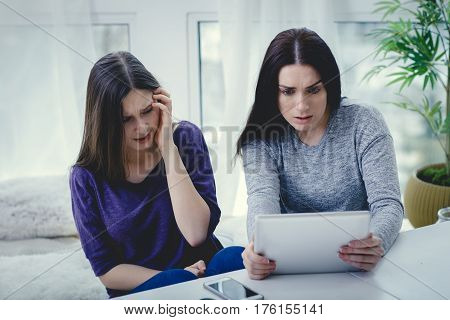 Scared mother arguing daughter over online activity. Cyber bullying or blue whale game concept
