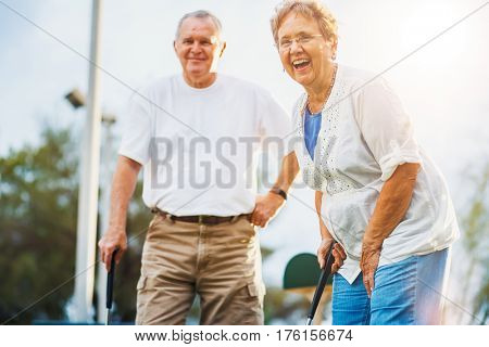 happy seniors playing mini golf
