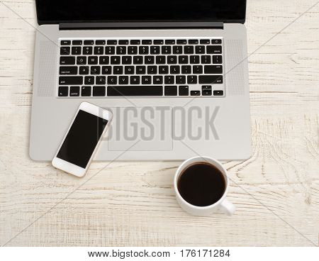 Top view of a laptop smart phonel and a cup of coffee