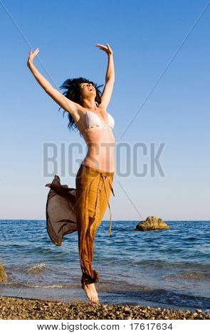 heureuse jeune femme sauter dans la plage