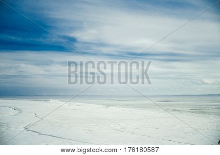 Blue clouds and frozen water. Winter landscape.
