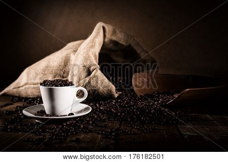 Background of cup of coffee beans with jute bag and bailer