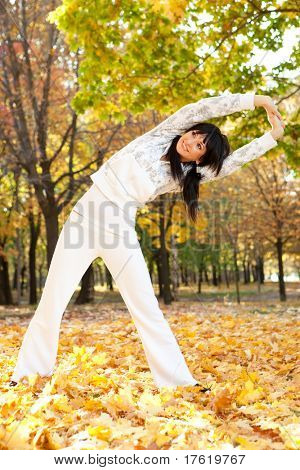 Pretty Woman doing Yoga-Übungen im Herbst park