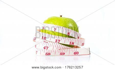 dieting and health food. Yellow green apple with tape measure
