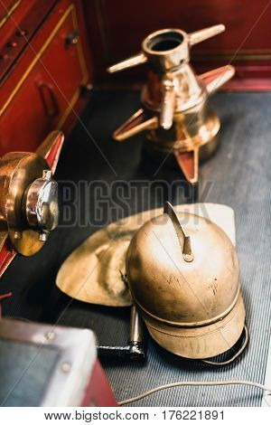 Golden Helmet Of Firefighter On Sidestep Of Fire Truck.