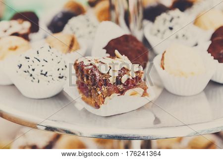 Caramel cakes on tray on banquet table. Pastry, biscuits, cookies and chocolate candies closeup