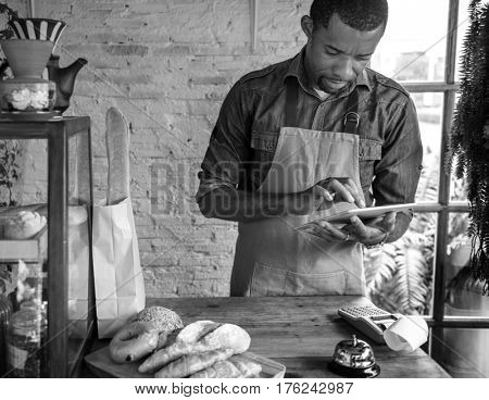 Adult Man Using Tablet in Bakery Shop