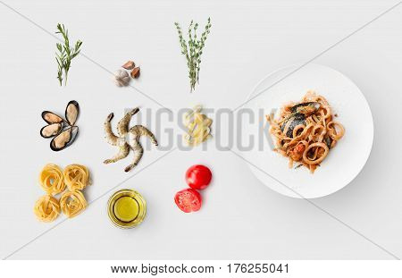 Cooking italian food, seafood pasta, isolated on white. Frutti di mare with fettuccine spaghetti. Mussels, prawn, shrimp, calamari rings and other ingredients around plate with dish