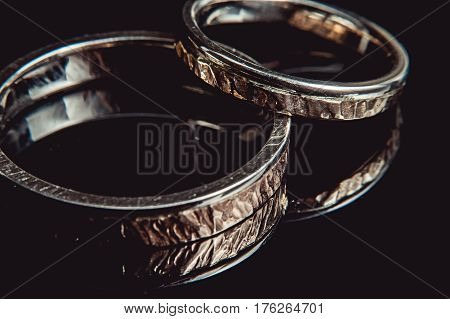 Hammered weddin rings on black background. macro. sparkle