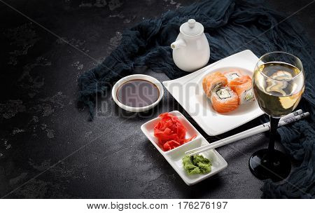 Sushi Roll On A White Plate, Decorated Like In Restaurant Over Dark Concrete Background
