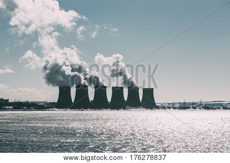 Cooling towers of NPP or Nuclear Power Plant with thick smoke. Dark toned image. Ecological disaster concept