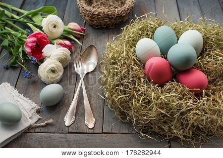 Easter decoration in vintage style with colorful eggs in a nest of straw