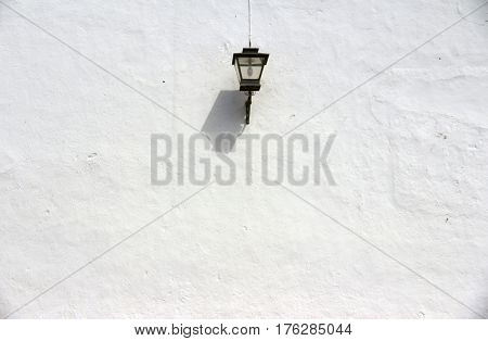 White wall with street lamp details on the streets of Andalusia Serrania de Ronda Spain.