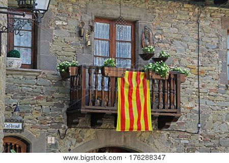 Rupit Spain - September 09 2014: Balcony with white petunias and Catalan flag in Rupit (Catalonia Spain)