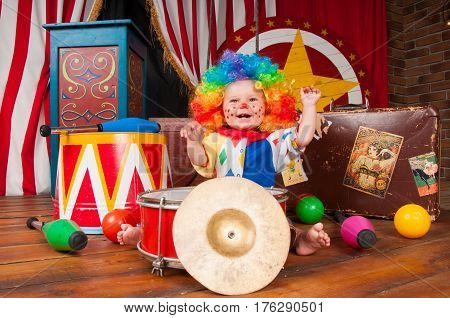 Little baby clown with red nose multi-colored wig in with balls.