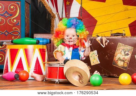 Little baby clown with red nose multi-colored wig in with balls.