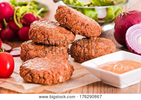Meatballs with salad and dip sauce on baking paper.