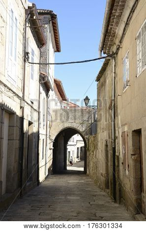TUI, SPAIN - AUGUST 7, 2016: Woman in an alley with a Small arch of Tui a town of the province of Pontevedra in Galicia Spain.