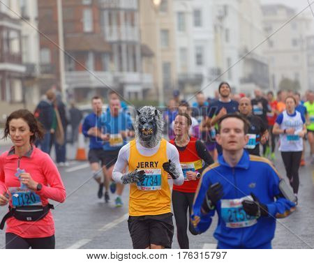 BRIGHTON GREAT BRITAIN - FEB 26 2017: Man dressed as a werewolf and competitors r running in the Vitality Brighton half marathon competition. February 26 2017 in Brighton Great Britain