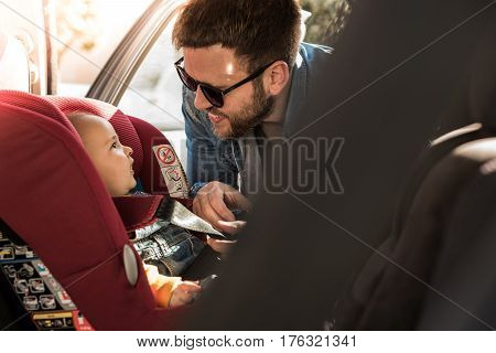 Father Fasten His Baby In Car Seat