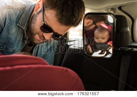 Father Fasten His Baby In Car Seat