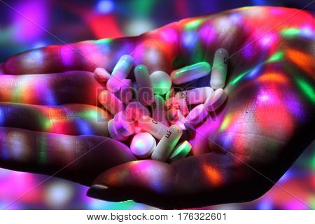 Drug dealing on disco / Open palm with white pill on the disco.