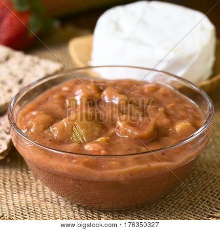 Homemade rhubarb and strawberry chutney in glass bowl photographed with natural light (Selective Focus Focus one third into the chutney)