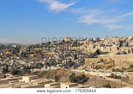 Dormition Abby, St. Peter in Gallicantu and al-Aqsa Mosque in a panoramic view of Jerusalem from a cemetery on the Mount of Olives in Israel beside the Kidron Valley.