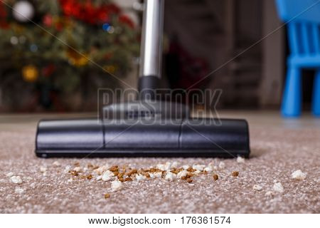 Vacuuming carpet with vacuum cleaner. Dirt on the rug. Housework service. Close up of the head of a sweeper cleaning device.