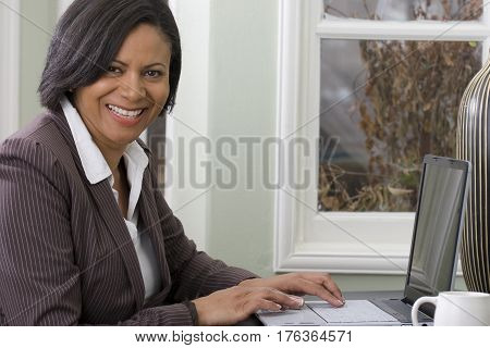 Confient African American woman working from home.