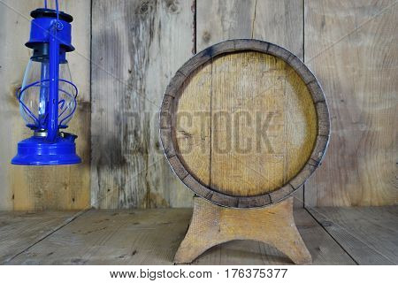 background of barrel and worn old table of wood and kerosene lamp