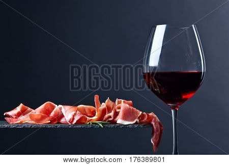 Prosciutto With Rosemary And Red Wine On A Black  Background