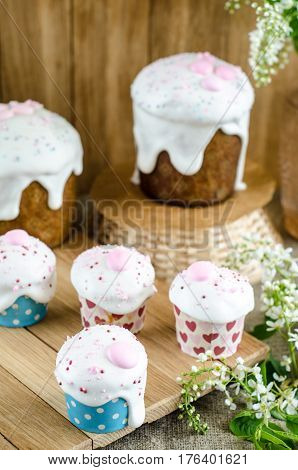 Easter cakes with white glaze on wooden table. Selective focus