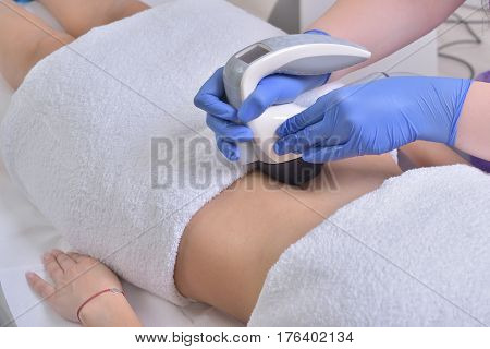 Young beautiful woman gets professional skin treatment in a professional beauty clinic. Body shaper