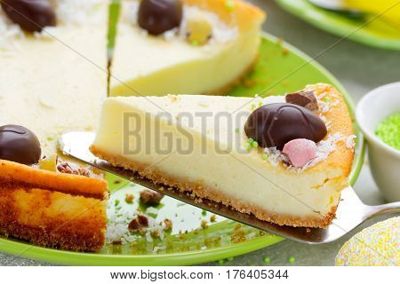 Easter cake cheesecake decorated with chocolate candy eggs on Easter table