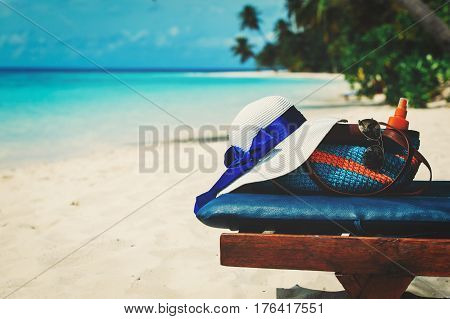Beach vacation concept - bag, sun glasses and suncream at sea coast
