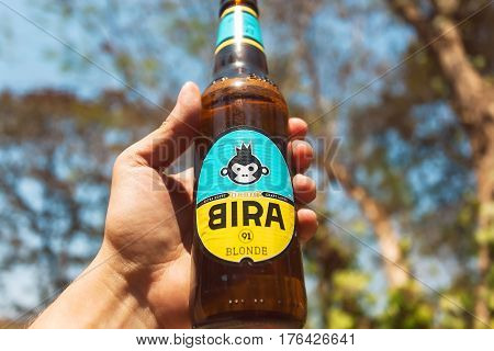 GOA, INDIA - FEB 28, 2017: Cold bottle of Indian craft blonde beer Bira 91 in a hand of drinker. Young company B9 Beverages owns Bira 91. 91 is international telephone code of India.