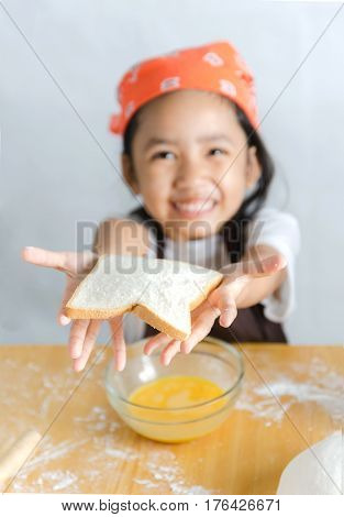 Asian little girl showing the bread select focus on bread shallow depth of field