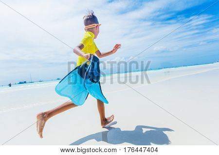 Photo of happy snorkeling boy in yellow swimwear on the white beach