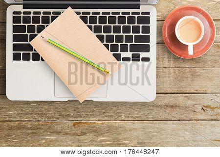 Notebooks and laptop with cup of coffee on office desk or wood table. top view with copy space for design