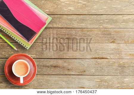 Notebooks and cup of coffee on office desk or wood table. top view with copy space for design