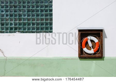 life preserver attached to a white and greenwall