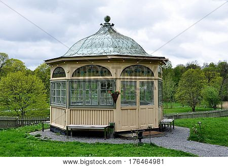 old wooden gazebo in a park in nature