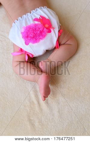 baby in little white panties lying on a homogeneous background