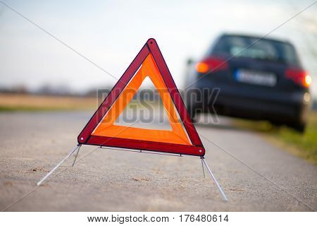 breakdown triangle stands near a broken car